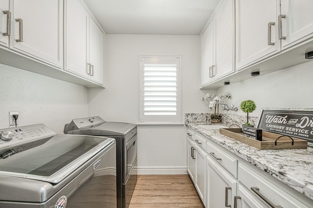 1039 N Burgan Ave, Clovis, CA 93611 - laundry area featuring washing machine and dryer, baseboards, light wood-style floors, and cabinet space