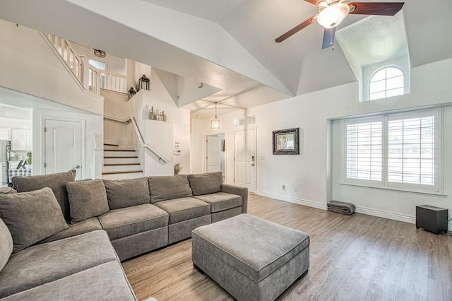 1039 N Burgan Ave, Clovis, CA 93611 - living area featuring ceiling fan, high vaulted ceiling, stairs, light wood-style flooring, and baseboards