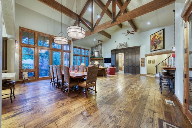 39516 Littleridge Rd, Shaver Lake, CA 93664 - dining room with high vaulted ceiling, beamed ceiling, hardwood / wood-style floors, a ceiling fan, and stairway