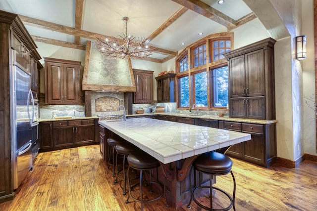 39516 Littleridge Rd, Shaver Lake, CA 93664 - kitchen with a chandelier, beamed ceiling, a kitchen island, decorative backsplash, and light wood-type flooring