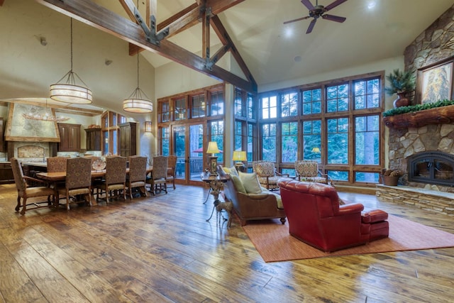 39516 Littleridge Rd, Shaver Lake, CA 93664 - living area with high vaulted ceiling, a ceiling fan, a fireplace, hardwood / wood-style flooring, and beamed ceiling