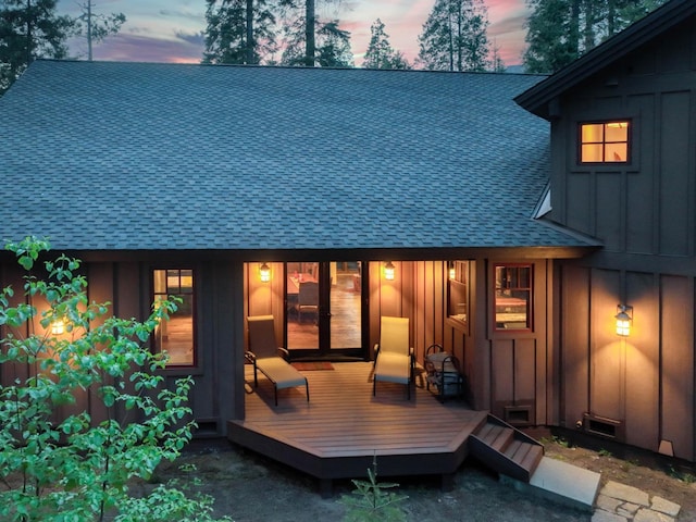 39516 Littleridge Rd, Shaver Lake, CA 93664 - back of property at dusk with board and batten siding, roof with shingles, and a wooden deck