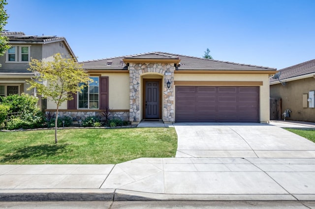 7347 E Andrews Ave, Fresno, CA 93737 - view of front of home featuring stone siding, an attached garage, concrete driveway, and a tile roof