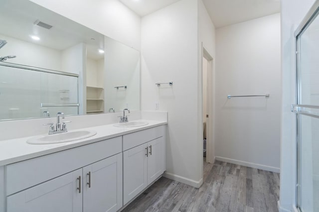 987 S Filbert Ave, Fresno, CA 93727 - full bath with wood finished floors, double vanity, a shower stall, and baseboards