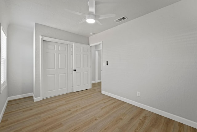 unfurnished bedroom with baseboards, light wood-style floors, and a closet