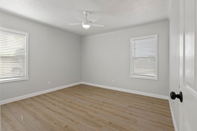 unfurnished room with ceiling fan, light wood-type flooring, and baseboards