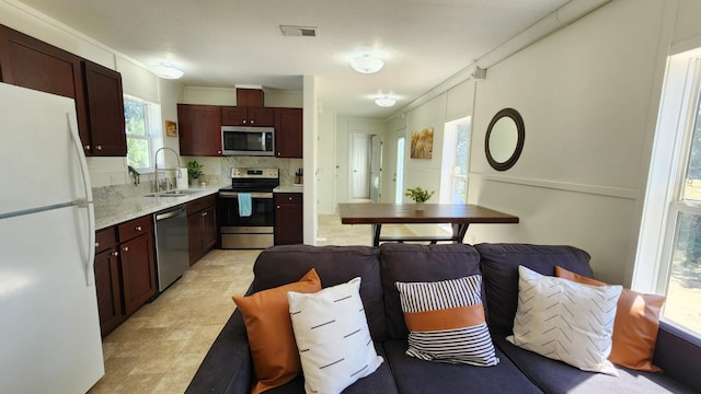 55062 Oak Crest Ct, Wishon, CA 93669 - kitchen featuring appliances with stainless steel finishes, a sink, open floor plan, and tasteful backsplash