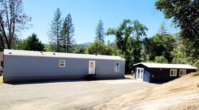 55062 Oak Crest Ct, Wishon, CA 93669 - manufactured / mobile home with an outbuilding, entry steps, and view of wooded area
