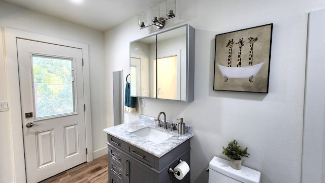 55062 Oak Crest Ct, Wishon, CA 93669 - half bathroom featuring wood finished floors, vanity, toilet, and baseboards