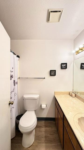 5455 N Marty Ave Unit 111, Fresno, CA 93711 - full bath featuring vanity, wood finished floors, toilet, baseboards, and a textured ceiling