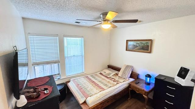 5455 N Marty Ave Unit 111, Fresno, CA 93711 - bedroom featuring wood finished floors, a textured ceiling, and ceiling fan