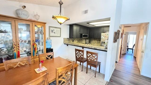 5455 N Marty Ave Unit 111, Fresno, CA 93711 - kitchen featuring appliances with stainless steel finishes, backsplash, dark cabinets, pendant lighting, and french doors