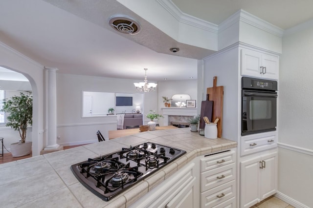 5753 N 7th St, Fresno, CA 93710 - kitchen featuring black appliances, arched walkways, tile counters, white cabinetry, and a chandelier