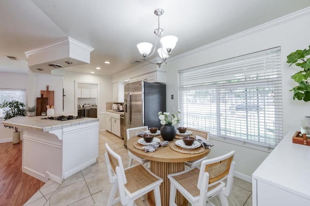 5753 N 7th St, Fresno, CA 93710 - dining room with ornamental molding, a chandelier, washing machine and clothes dryer, baseboards, and light tile patterned floors
