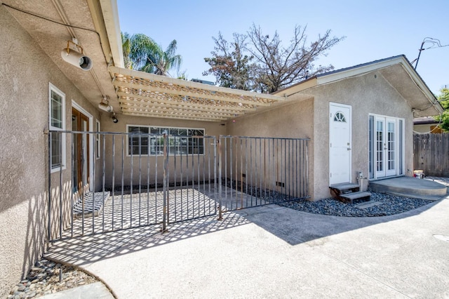 5753 N 7th St, Fresno, CA 93710 - view of exterior entry with french doors, stucco siding, and a gate