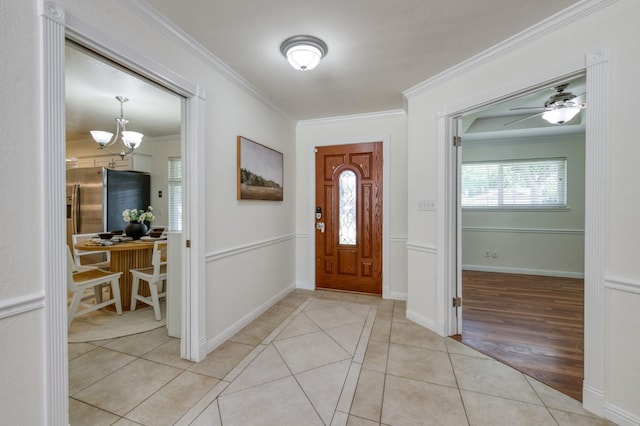 5753 N 7th St, Fresno, CA 93710 - entrance foyer with crown molding, light tile patterned floors, a chandelier, baseboards, and a ceiling fan