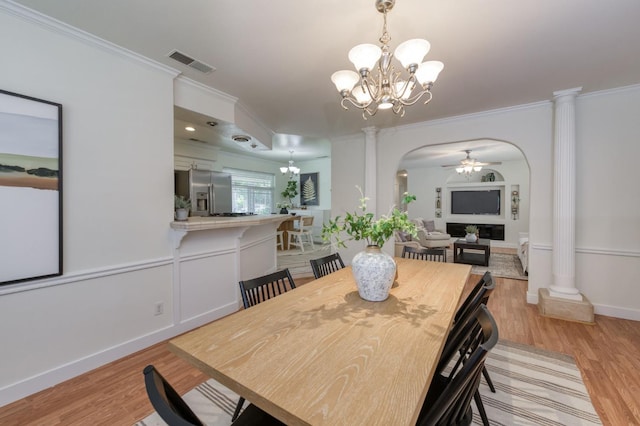 5753 N 7th St, Fresno, CA 93710 - dining area with arched walkways, ornate columns, a chandelier, crown molding, and light wood-type flooring