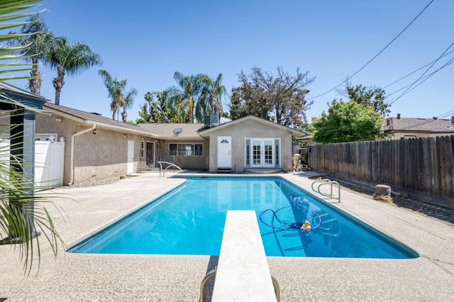 5753 N 7th St, Fresno, CA 93710 - view of swimming pool featuring a patio area, a fenced backyard, french doors, and a diving board