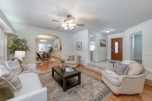 5753 N 7th St, Fresno, CA 93710 - living room with arched walkways, crown molding, light wood finished floors, a chandelier, and ceiling fan