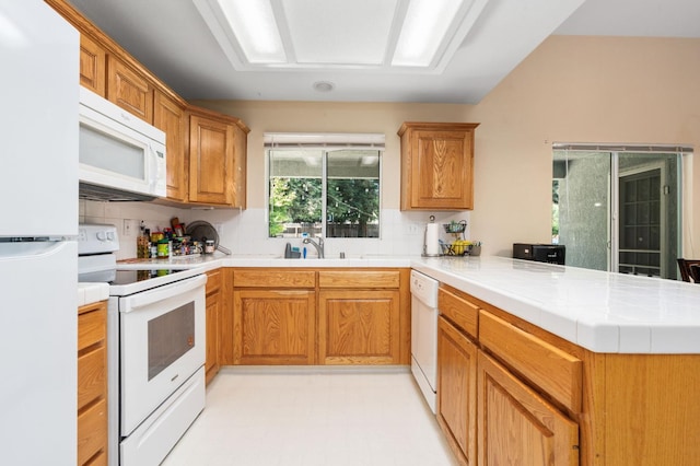 2173 Spruce, Clovis, CA 93611 - kitchen featuring white appliances, a peninsula, tasteful backsplash, tile counters, and a sink