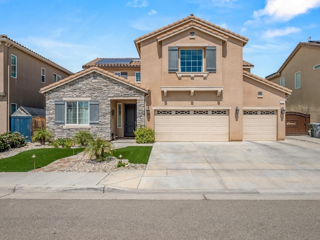 2127 Chennault Ave, Clovis, CA 93611 - view of front of home with solar panels, a garage, stucco siding, and stone siding