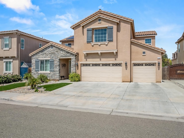 2127 Chennault Ave, Clovis, CA 93611 - view of front of property with a garage, a tiled roof, stucco siding, driveway, and stone siding