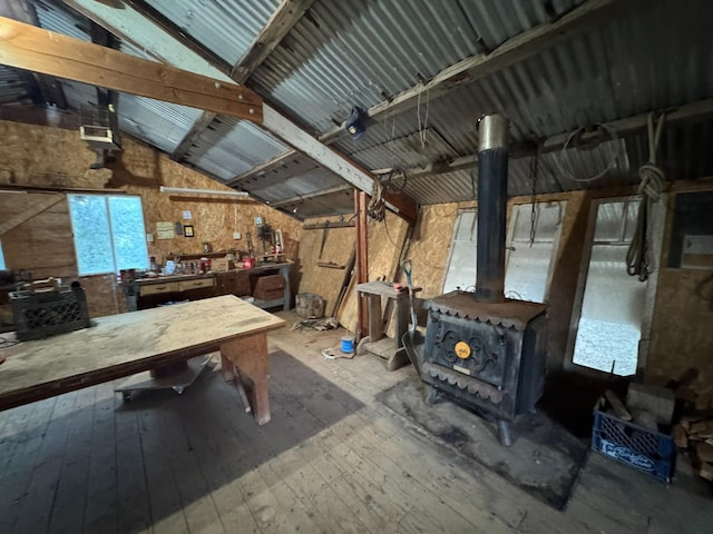 32101 E Trimmer Springs Rd, Sanger, CA 93657 - miscellaneous room with lofted ceiling, a workshop area, a wood stove, and hardwood / wood-style floors