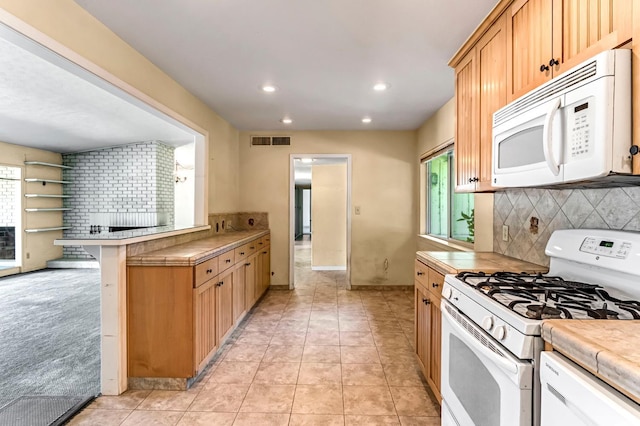 5495 E Atchison St, Fresno, CA 93727 - kitchen featuring white appliances, tasteful backsplash, recessed lighting, a peninsula, and tile counters