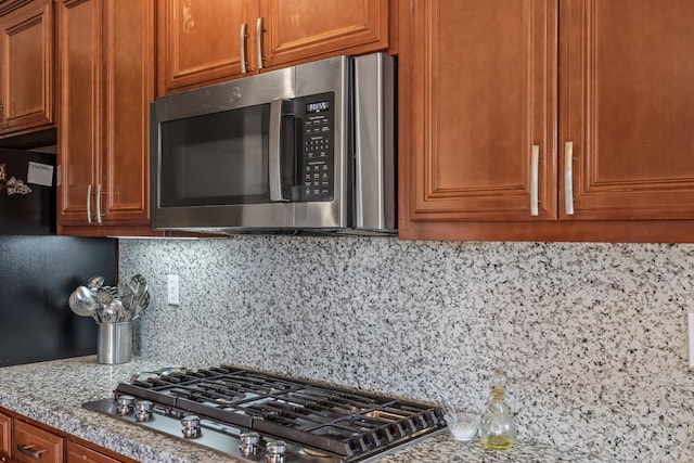 3615 W Sunnyview Ave NW, Visalia, CA 93291 - kitchen featuring stainless steel appliances, tasteful backsplash, and brown cabinetry