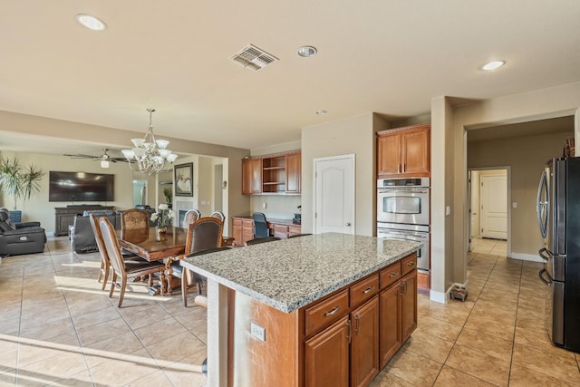 3615 W Sunnyview Ave NW, Visalia, CA 93291 - kitchen with stainless steel appliances, open floor plan, light tile patterned floors, a chandelier, and a center island