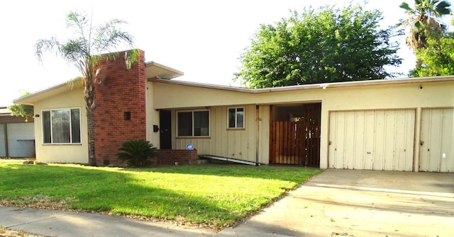 4457 E Brown Ave, Fresno, CA 93703 - view of front of property featuring a chimney, a front yard, concrete driveway, and stucco siding