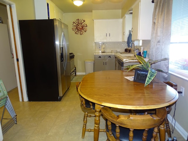 4457 E Brown Ave, Fresno, CA 93703 - kitchen with appliances with stainless steel finishes, white cabinetry, a sink, light countertops, and decorative backsplash