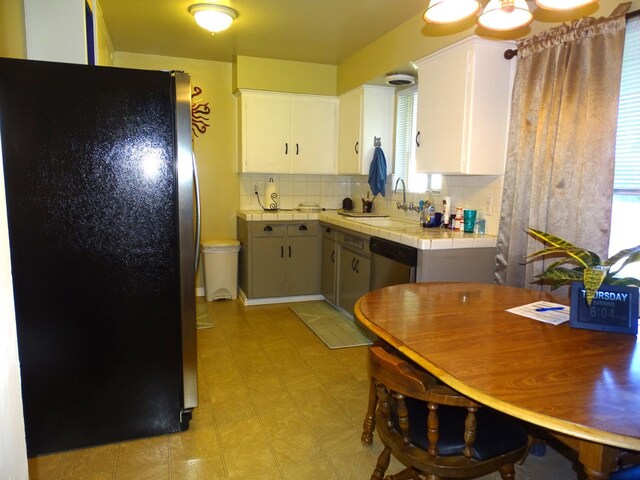 4457 E Brown Ave, Fresno, CA 93703 - kitchen with appliances with stainless steel finishes, tile countertops, a sink, decorative backsplash, and white cabinetry