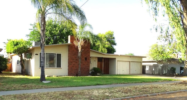 4457 E Brown Ave, Fresno, CA 93703 - view of front facade featuring stucco siding, a front lawn, and a chimney