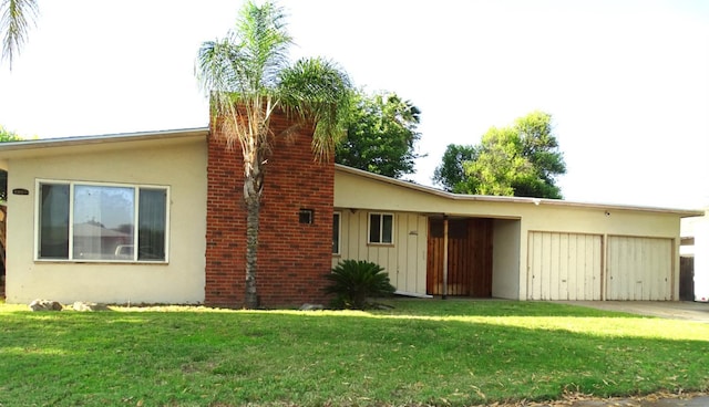 4457 E Brown Ave, Fresno, CA 93703 - rear view of house with a garage, stucco siding, a lawn, concrete driveway, and board and batten siding