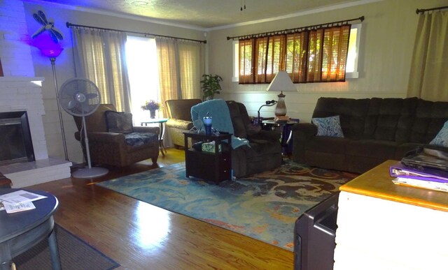 4457 E Brown Ave, Fresno, CA 93703 - living room with wood finished floors, ornamental molding, and a brick fireplace