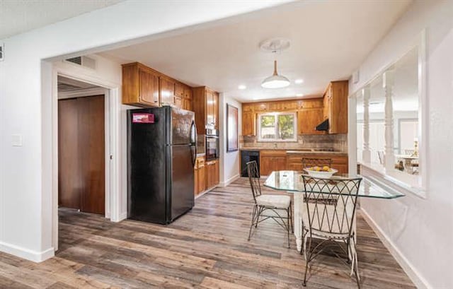6224 N 3rd St, Fresno, CA 93710 - kitchen with freestanding refrigerator, oven, brown cabinetry, light wood-style floors, and decorative light fixtures