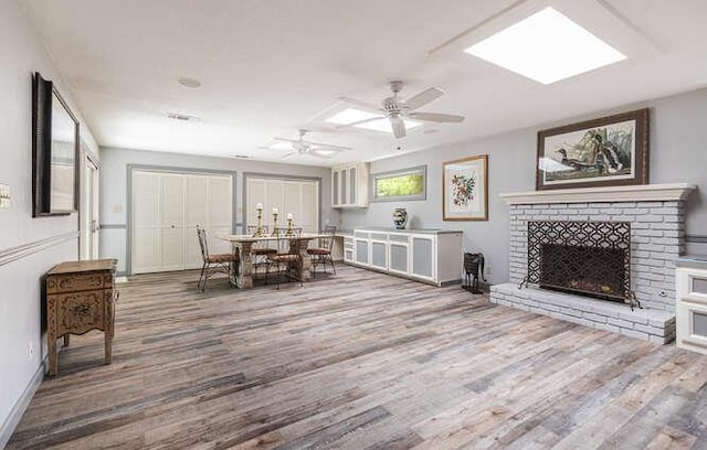 6224 N 3rd St, Fresno, CA 93710 - dining room with wood finished floors, a brick fireplace, and a ceiling fan