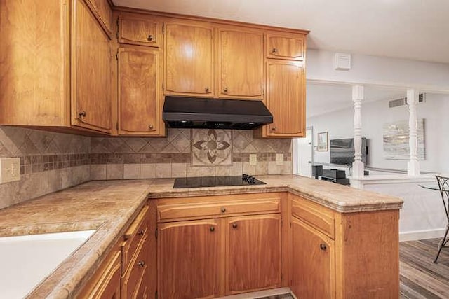 6224 N 3rd St, Fresno, CA 93710 - kitchen with under cabinet range hood, black electric stovetop, a peninsula, light countertops, and tasteful backsplash