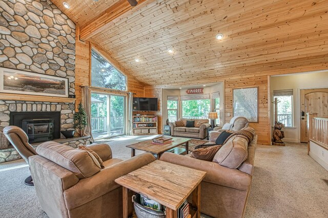 40753 Wild Iris Ln, Shaver Lake, CA 93664 - carpeted living room featuring high vaulted ceiling, wooden ceiling with exposed beams, wooden walls, and a stone fireplace