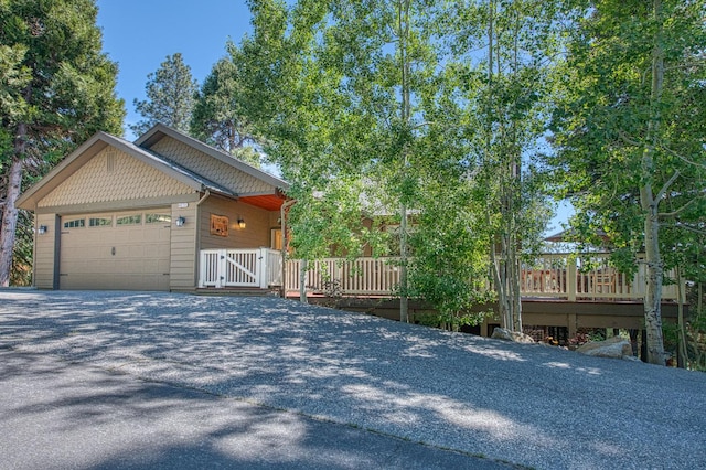 40753 Wild Iris Ln, Shaver Lake, CA 93664 - view of property exterior featuring an attached garage, driveway, and a wooden deck