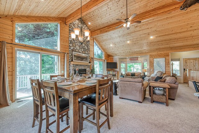 40753 Wild Iris Ln, Shaver Lake, CA 93664 - carpeted dining room with wood ceiling with exposed beams, high vaulted ceiling, a stone fireplace, a chandelier, and ceiling fan
