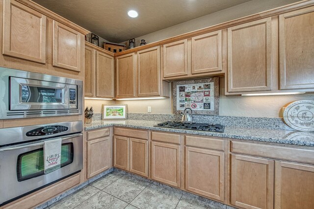 40753 Wild Iris Ln, Shaver Lake, CA 93664 - kitchen with stainless steel appliances, light brown cabinetry, light stone countertops, recessed lighting, and light tile patterned floors
