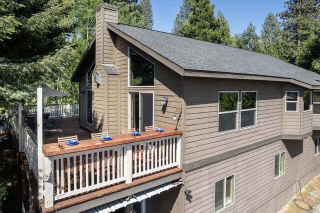 40753 Wild Iris Ln, Shaver Lake, CA 93664 - back of property featuring a chimney, a deck, and roof with shingles