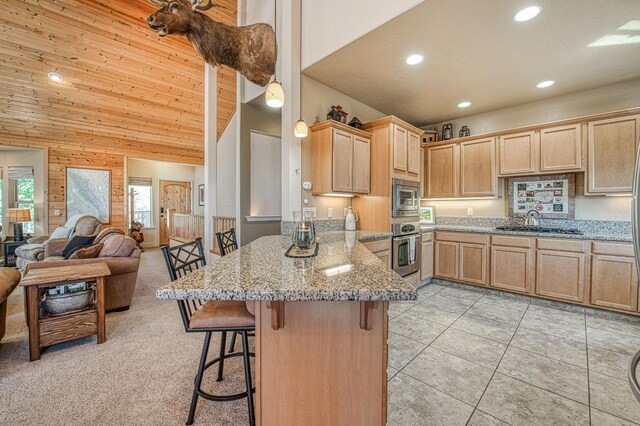 40753 Wild Iris Ln, Shaver Lake, CA 93664 - kitchen with appliances with stainless steel finishes, light brown cabinets, a peninsula, recessed lighting, and a breakfast bar