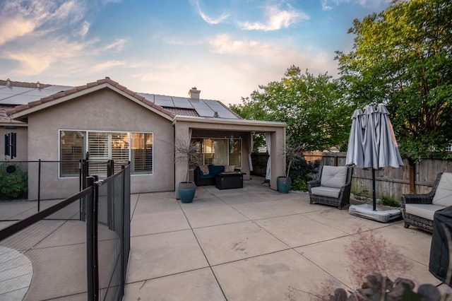 10485 N Sinclair Cir, Fresno, CA 93730 - rear view of house featuring an outdoor living space, a patio area, stucco siding, roof mounted solar panels, and a fenced backyard