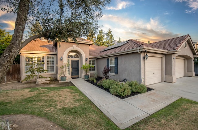 10485 N Sinclair Cir, Fresno, CA 93730 - mediterranean / spanish-style house with a tile roof, a garage, stucco siding, solar panels, and driveway