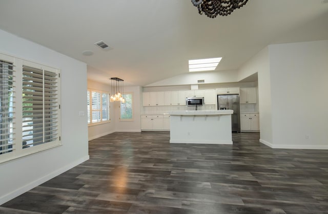 10485 N Sinclair Cir, Fresno, CA 93730 - kitchen with appliances with stainless steel finishes, a chandelier, vaulted ceiling, white cabinets, and baseboards