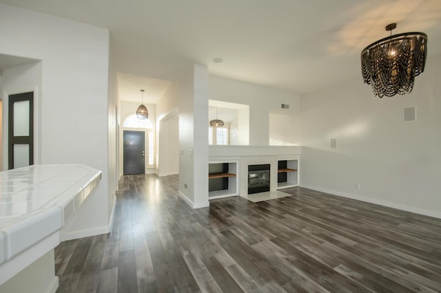 10485 N Sinclair Cir, Fresno, CA 93730 - unfurnished living room with dark wood-type flooring, a chandelier, and baseboards