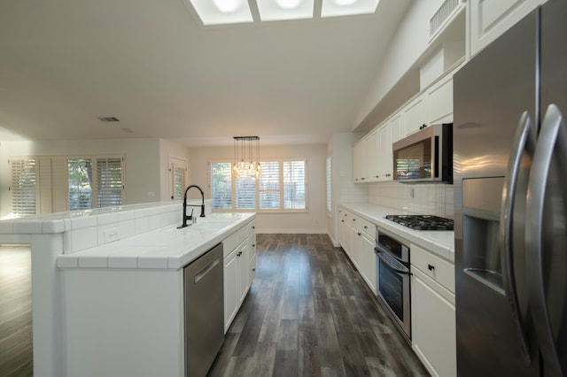 10485 N Sinclair Cir, Fresno, CA 93730 - kitchen with stainless steel appliances, tile counters, a sink, dark wood-style floors, and white cabinetry